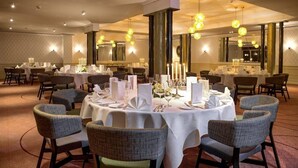 A dining area with round tables, chairs, and candle centerpieces. - Hotel-restaurant Erbprinz (Ettlingen)