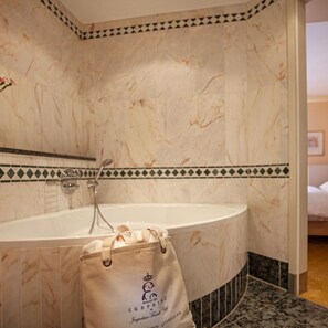 A bathroom with a marble sink, a towel, and a bag with text. - Hotel-restaurant Erbprinz (Ettlingen)