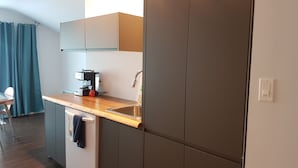 Eine moderne Küche mit eingebautem Geschirrspüler, einer Kaffeemaschine und einem Spülbecken.