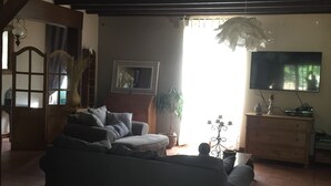 Ein Wohnzimmer mit Sofa, Fernseher und einer Treppe.