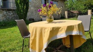 A round table with a yellow tablecloth, two chairs, and a vase with flowers. - Independent apartment, - 4 people (Reillanne)