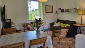 A living room with a dining table, chairs, a sofa, a lamp, and a bookshelf. - Independent apartment, - 4 people (Reillanne)