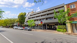 A multi-story building with a modern architectural design, featuring a ground-level commercial space and upper residential or office units. - Breakfree North Adelaide (North Adelaide)