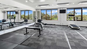 A gym with exercise equipment, large windows, and a flat-screen TV. - Breakfree North Adelaide (North Adelaide)