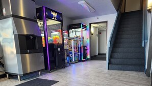 A spacious lobby with marble flooring, vending machines, and a staircase. - The Oasis Hotel & Bar (Sheboygan Falls)