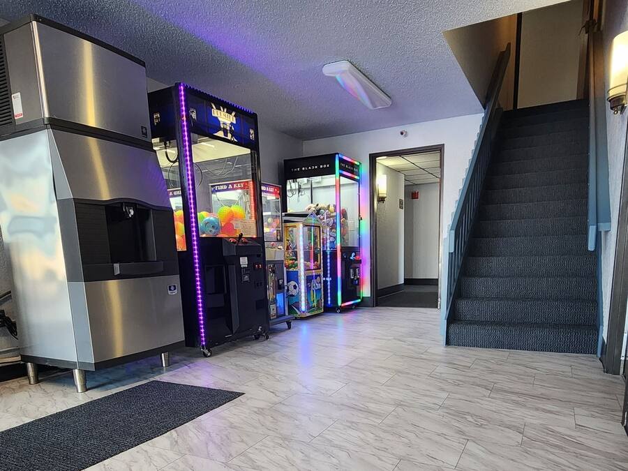 A spacious lobby with marble flooring, vending machines, and a staircase.