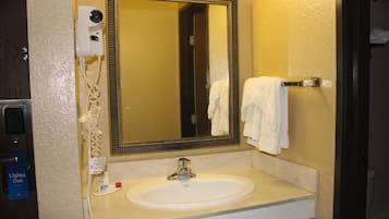 A bathroom with a white sink, a mirror, a towel rack, and a hairdryer.