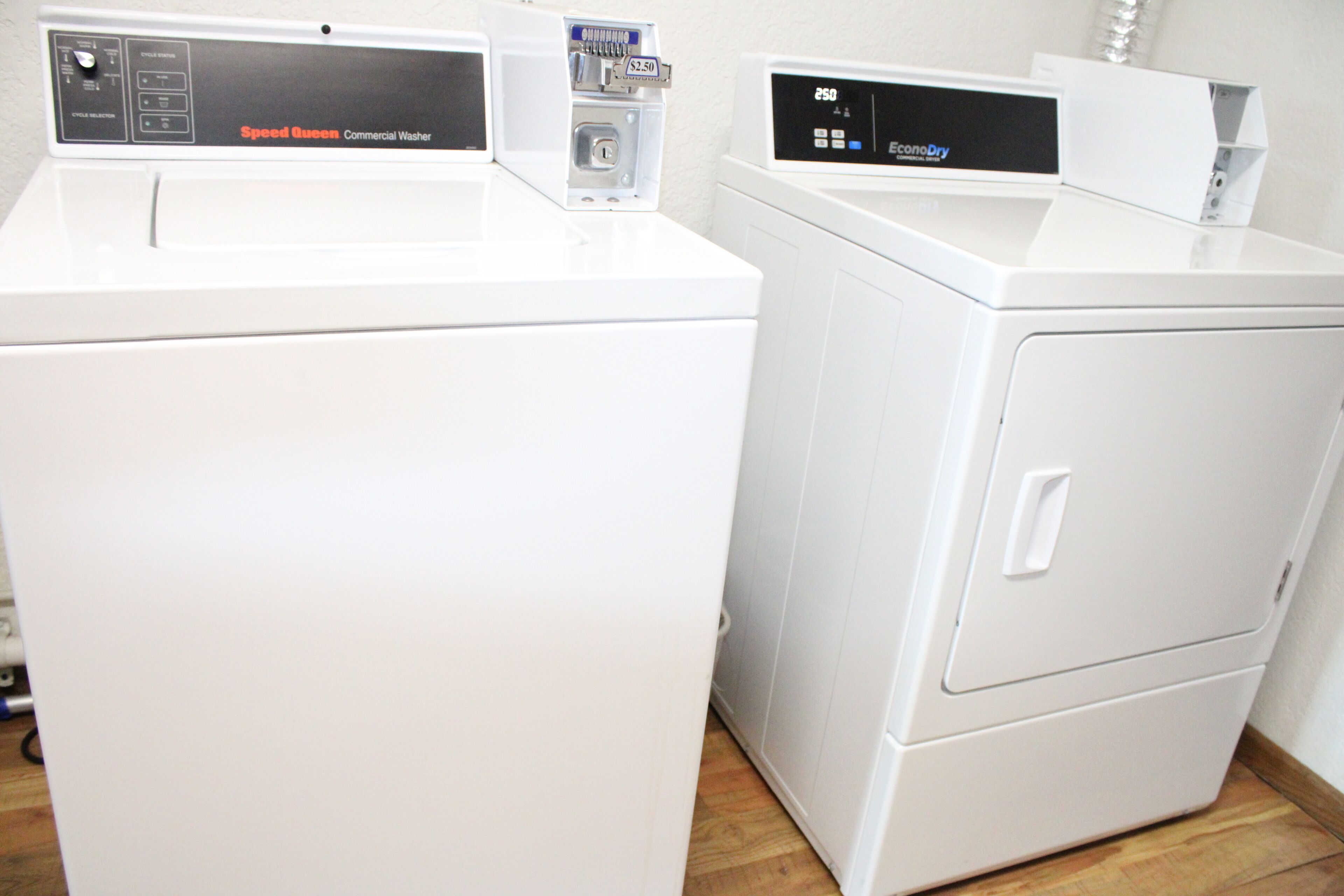 Two white commercial washers with control panels, one labeled "Speed Queen" and the other "EcoDry."