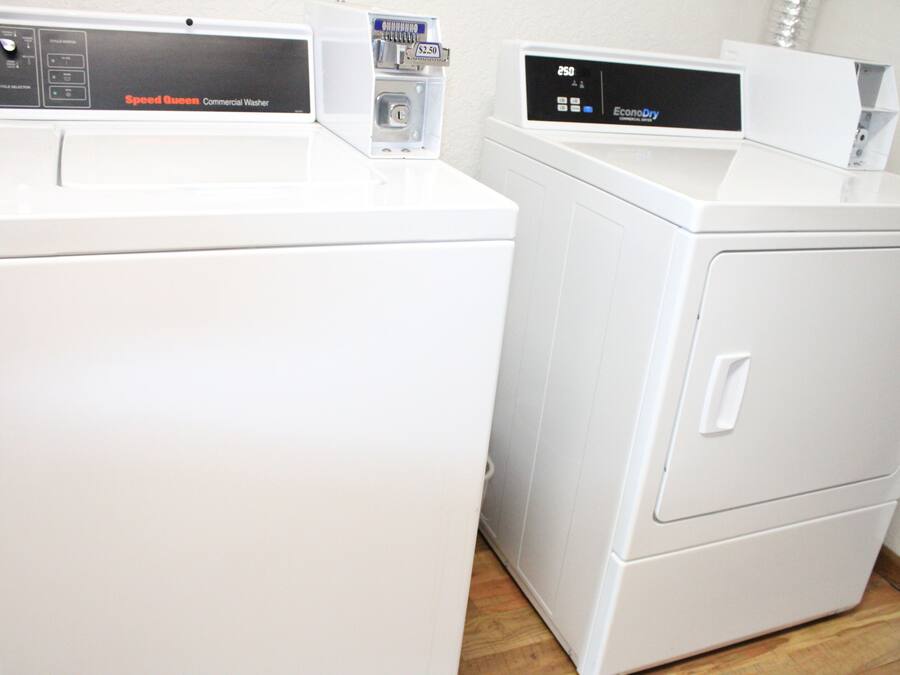 Two white commercial washers with control panels, one labeled "Speed Queen" and the other "EcoDry."