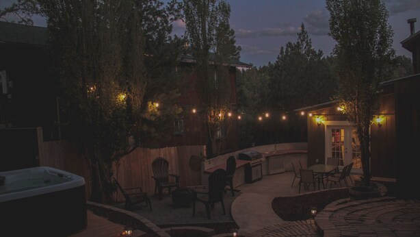 Eine Terrassenanlage mit Whirlpool, Sitzgelegenheiten und Grill.