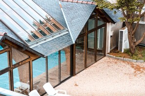A modern building with large glass windows and a swimming pool. - 3-Star Tourist DUPLEX WITH OCEAN VIEW, Balcony, and Swimming Pool (Penmarch)