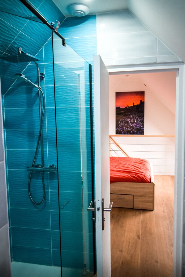 A modern bathroom with a glass shower enclosure and a visible showerhead. - 3-Star Tourist DUPLEX WITH OCEAN VIEW, Balcony, and Swimming Pool (Penmarch)