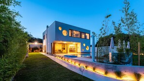 Une maison moderne à deux étages, dotée d’un hall d’entrée bien éclairé, d’un jardin aménagé et d’une piscine.