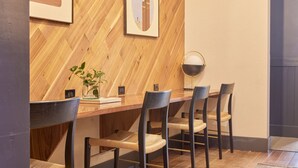 A dining area with a wooden herringbone wall, a long table, and six chairs. - FOUND Hotel, San Francisco (San Francisco)