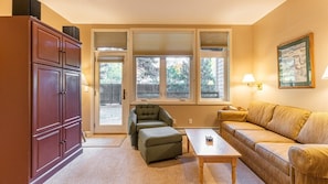 Relax in this inviting living room with a comfortable sofa, ottoman, and coffee table.