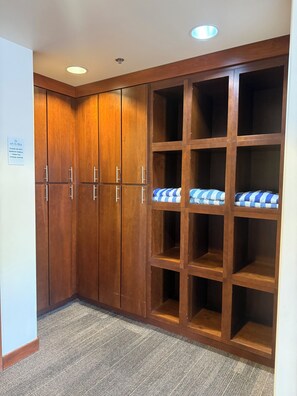 A corner room with wooden cabinets and a sign instructing not to remove towels from the fitness center.