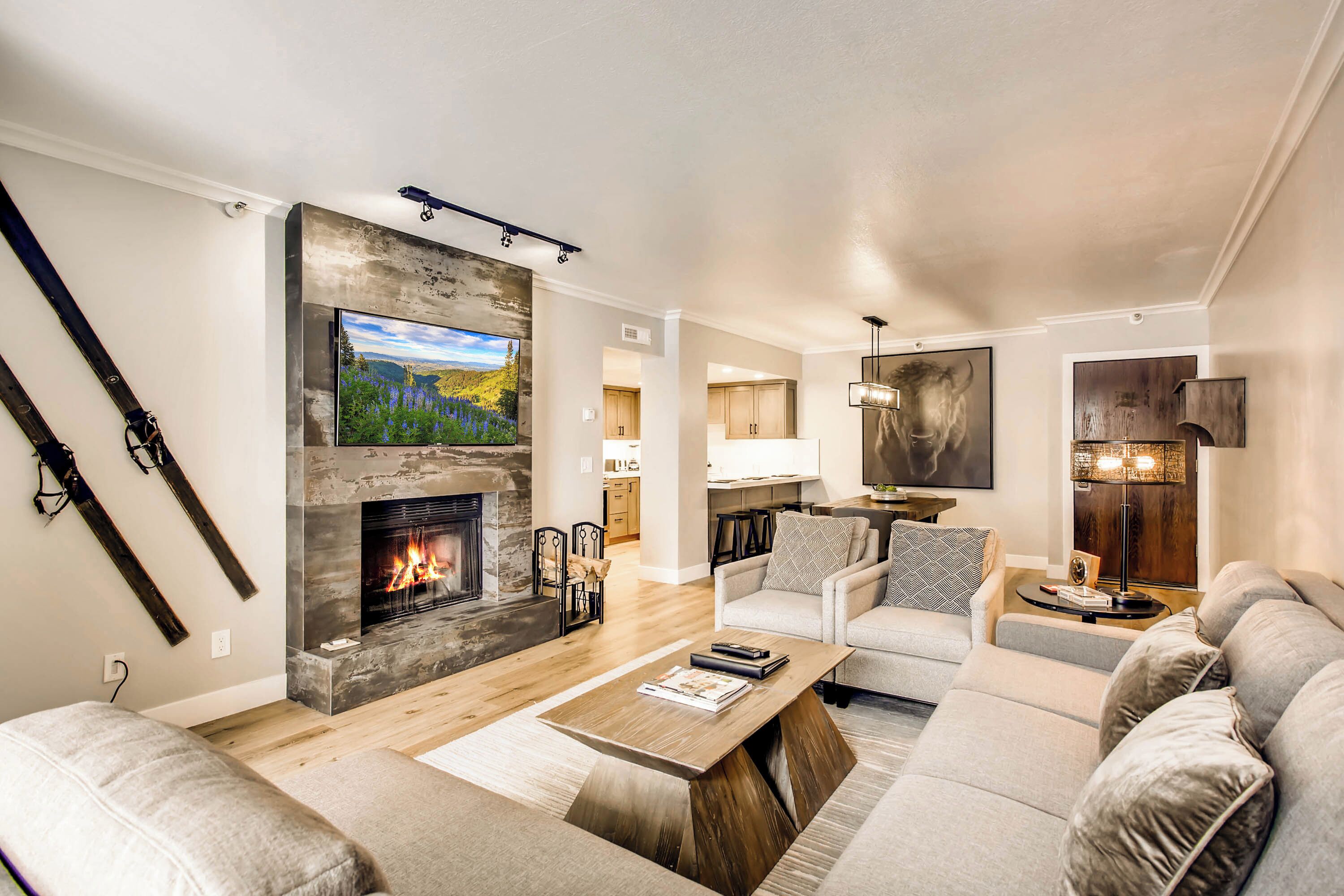 A modern living room with a fireplace, a flat-screen TV, and a sofa set.