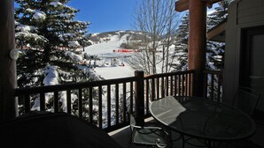 A balcony with a view of a snow-covered ski slope and a clear blue sky. - Managed by Park City Lodging-True Ski-In/Ski-Out to Park City Mountain Resort! (Park City)