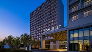 A modern hotel with a prominent "SOMERSET" sign, multiple floors, and a well-lit entrance. - Somerset Daxing Beijing (Daxing)