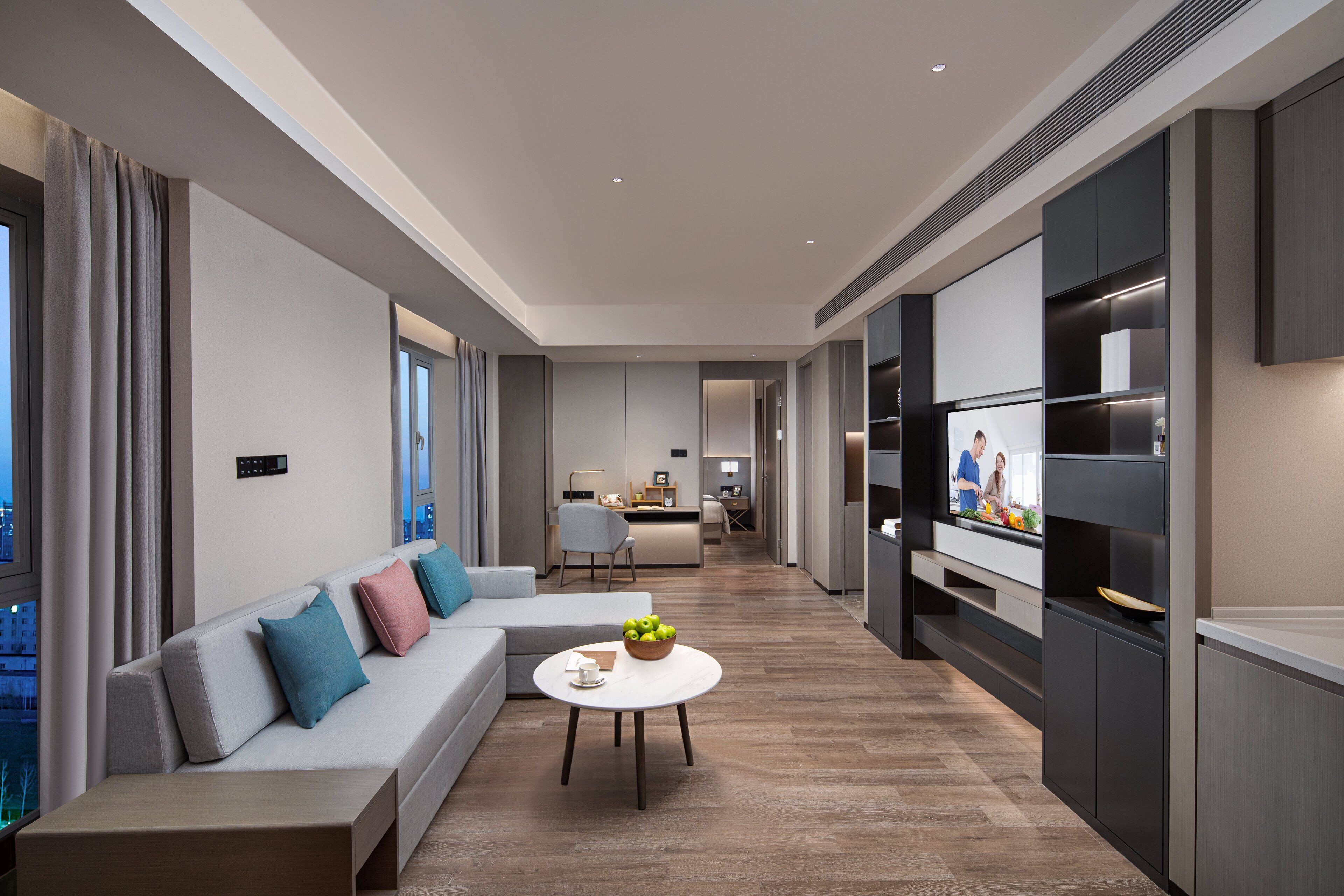 A modern living room with a sofa, a coffee table, and a TV.