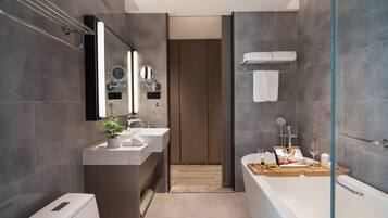 A modern bathroom with a bathtub, a sink, a mirror, and a shower area.