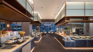 A modern hotel lobby with a marble reception desk, seating area, and a view of the cityscape through large windows. - Somerset Daxing Beijing (Daxing)