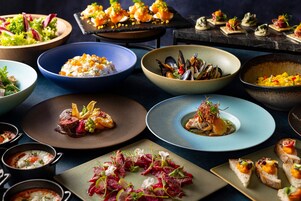 A variety of dishes on a table, including seafood, salads, and appetizers.