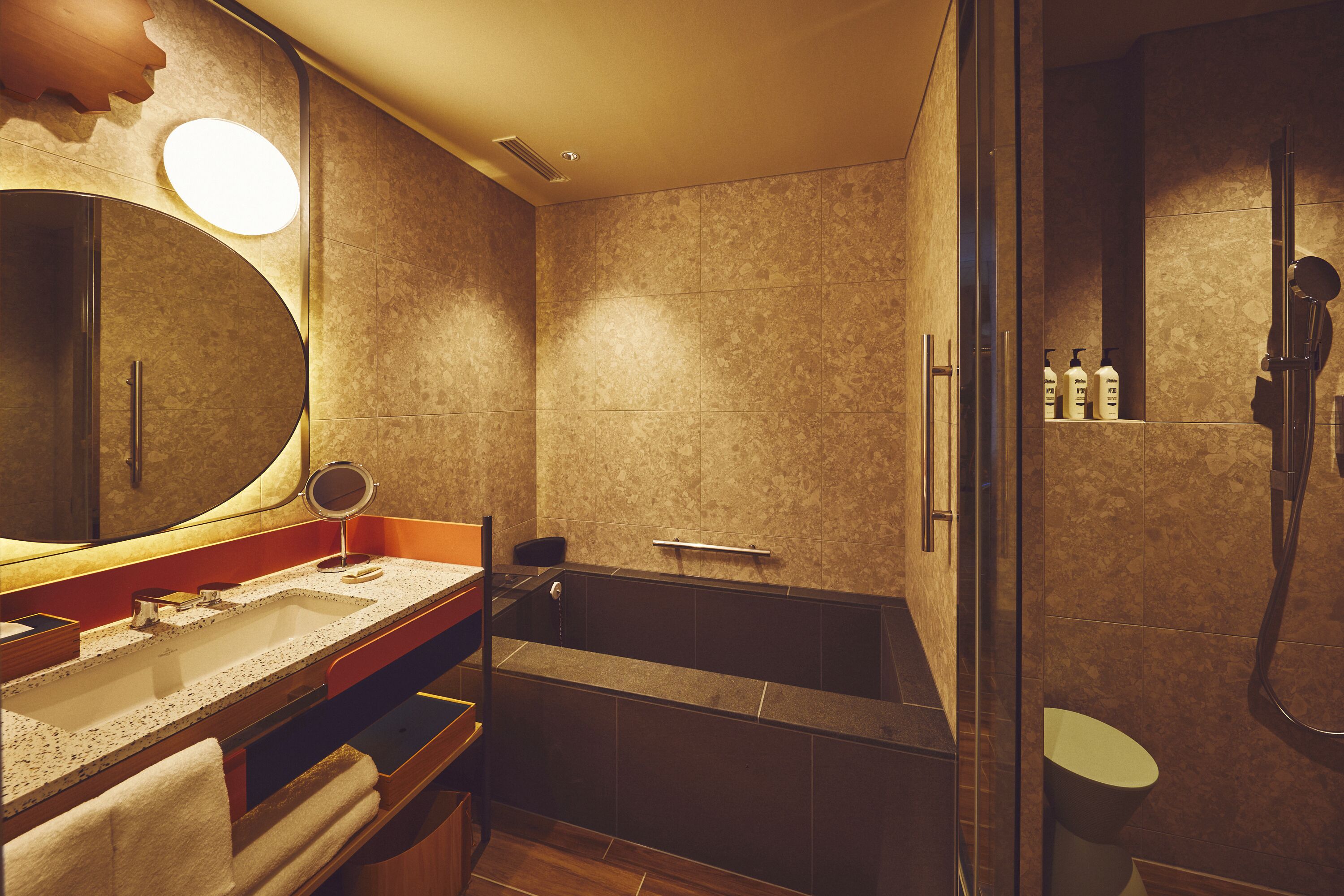 A modern bathroom with a large mirror, a sink, a bathtub, and a shower.
