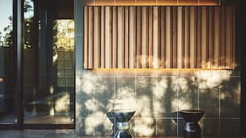 A modern interior with a large vertical panel and two decorative bowls on a tiled floor.
