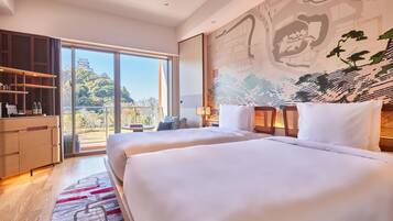 A modern hotel room with two beds, a large window, a wooden wardrobe, and a mural on the wall.