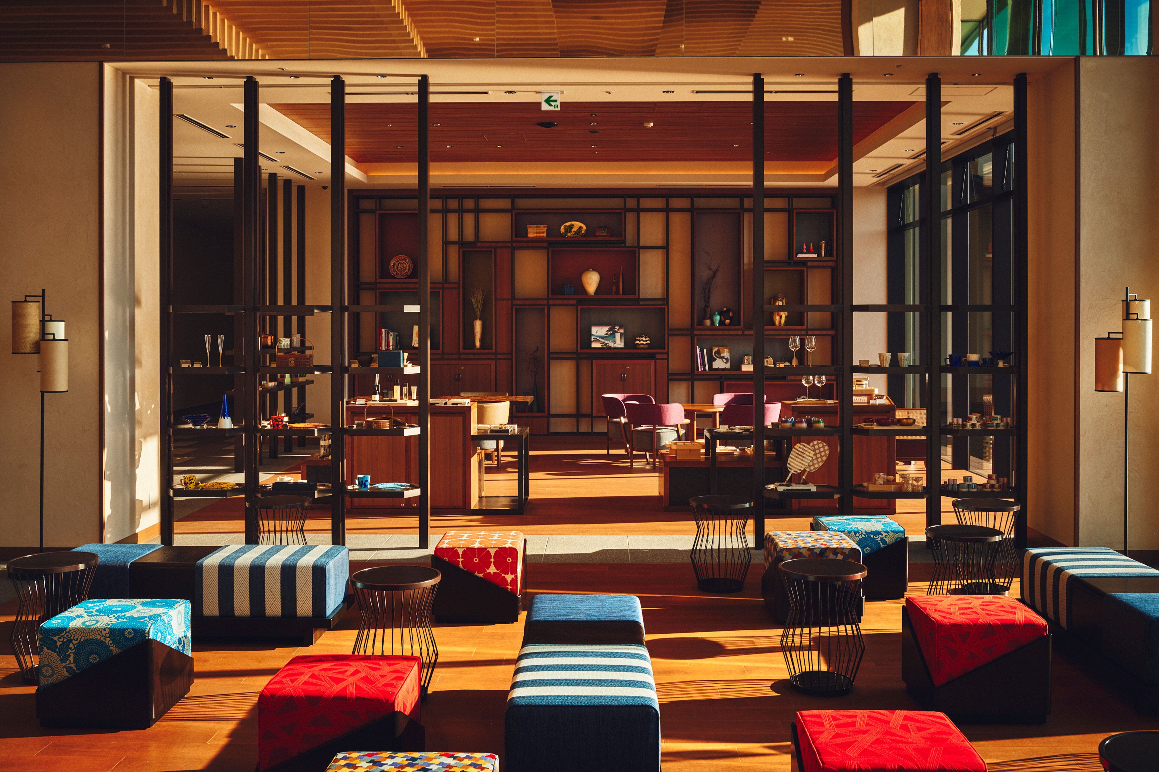 Un vestíbulo de hotel moderno con una zona de estar central, un mostrador de recepción y vistas al comedor.