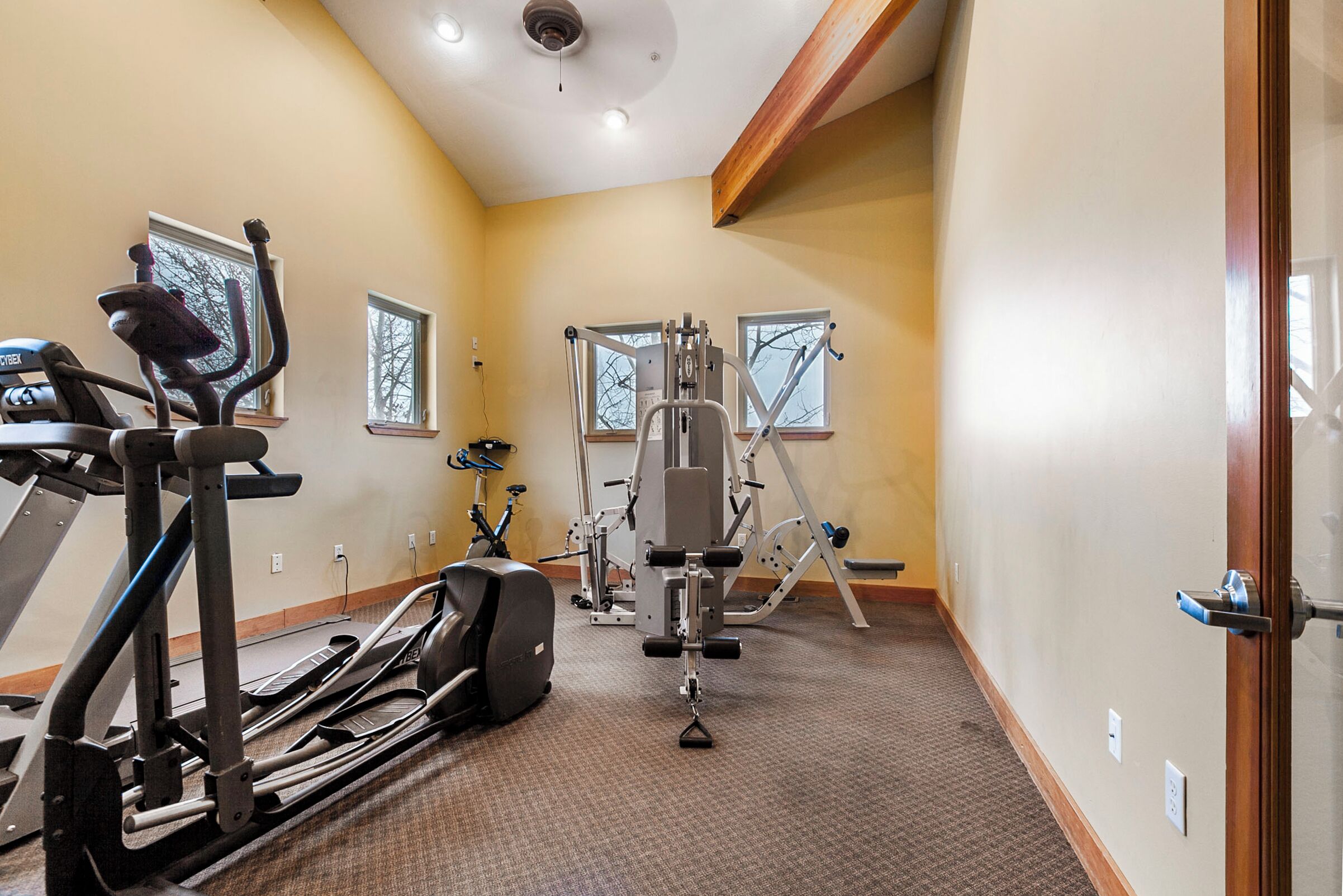 A gym with treadmills, elliptical machines, and weight equipment.