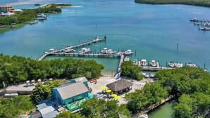 A marina with boats docked, a pier extending into the water, and a small building with a thatched roof. - My Sea Shack~ 1 minute to beach, SH Club access, golf cart (Lee County)