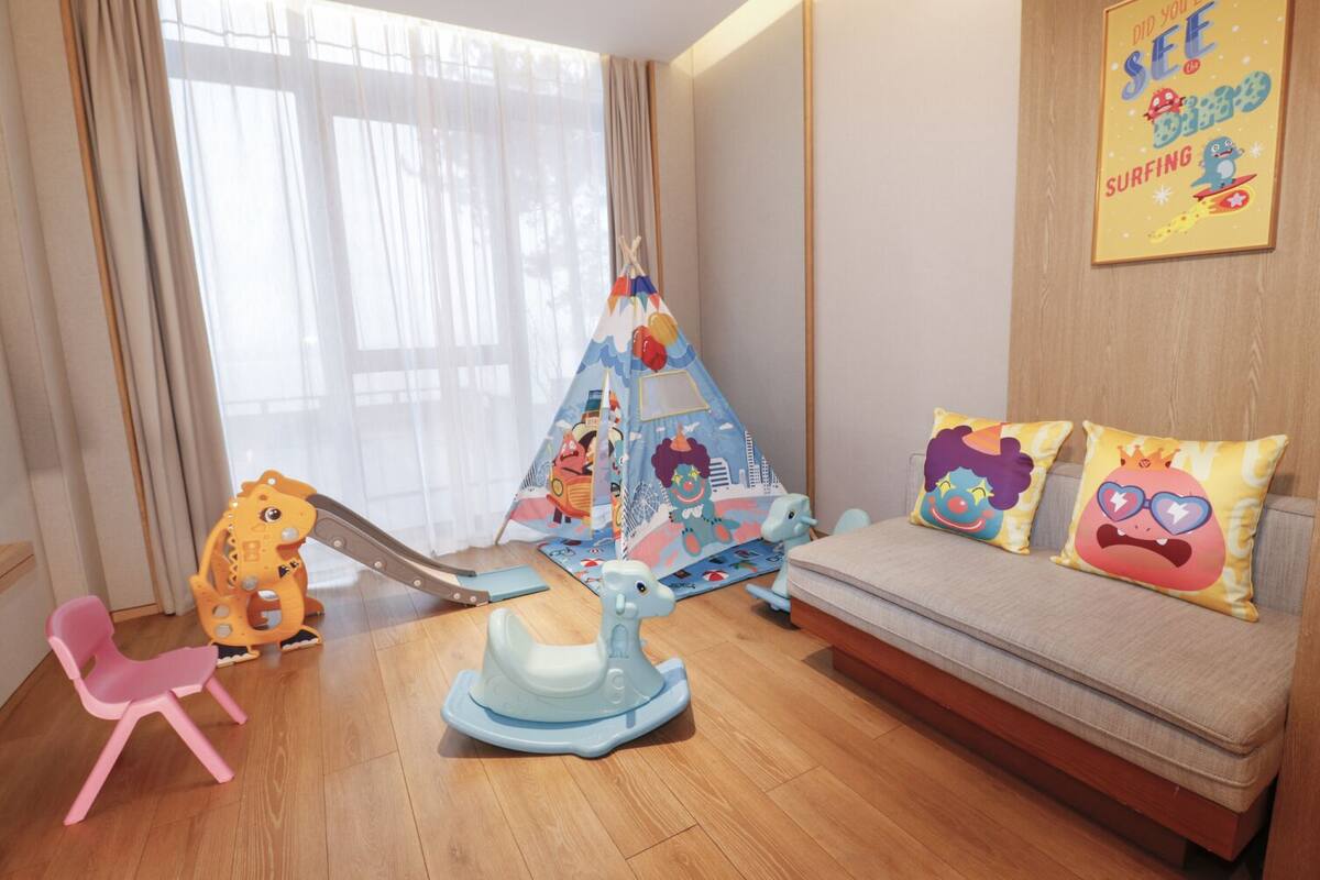 A child's play area with a slide, a tent, and a sofa with colorful pillows.