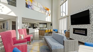 A spacious lobby with modern seating, a kitchen area, and a large TV screen. - Best Western Plus Harrisonburg (Harrisonburg)