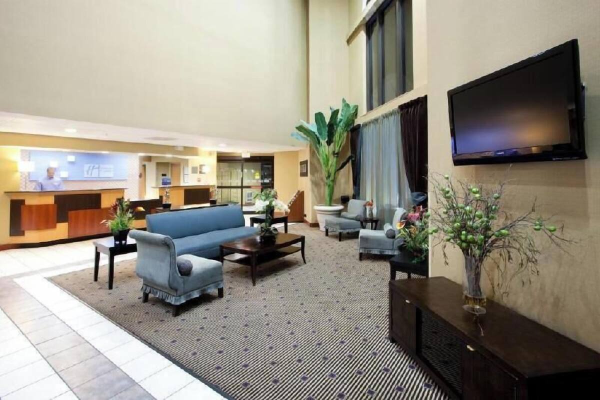 Un hall d’hôtel comprenant un comptoir d’accueil, un espace salon et un téléviseur fixé au mur.