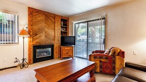 A living room with a fireplace, a television, a sofa, and a coffee table.