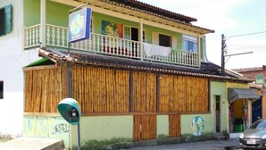 A two-story building with a balcony, a parking meter, and a signboard. - Vibe hostel Paraty (Paraty)