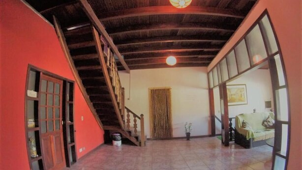 A spacious interior with a high ceiling, a staircase, and a large window. - Vibe hostel Paraty (Paraty)
