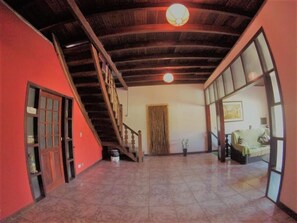A spacious interior with a high ceiling, a staircase, and a large window. - Vibe hostel Paraty (Paraty)