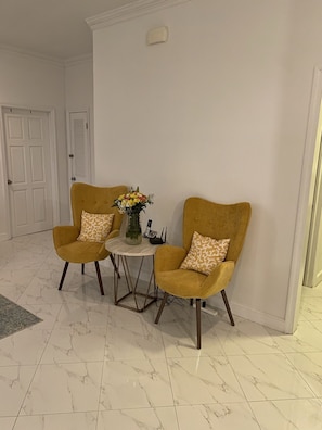 Relax in a serene space with a round table and two comfortable armchairs.