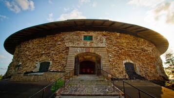 A stone building with a circular roof and a central entrance.