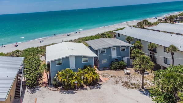 A beachfront property with multiple buildings, a sandy beach, and a clear view of the ocean. - Beachfront Unit-Upstairs-Walking Distance to all Bars and Restaurants (Englewood)