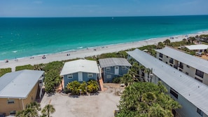 A beachfront property with multiple buildings, a sandy beach, and a view of the ocean. - Beachfront Unit-Upstairs-Walking Distance to all Bars and Restaurants (Englewood)