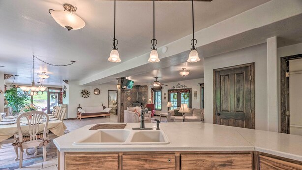 Una cocina amplia con una isla grande, armarios de madera e iluminación colgante.