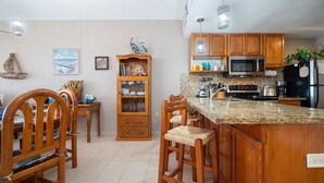 A kitchen with wooden cabinets, a granite countertop, a built-in oven, and a microwave.