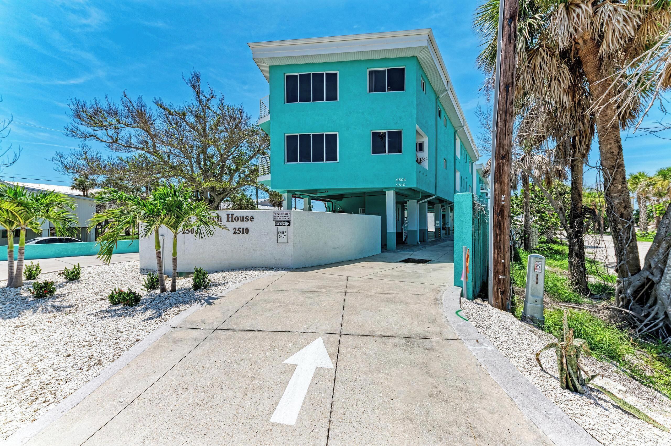 Un bâtiment à deux étages, sur lequel on peut lire une enseigne indiquant « Maison 2504 2510 » et un panneau « SENS UNIQUE ».