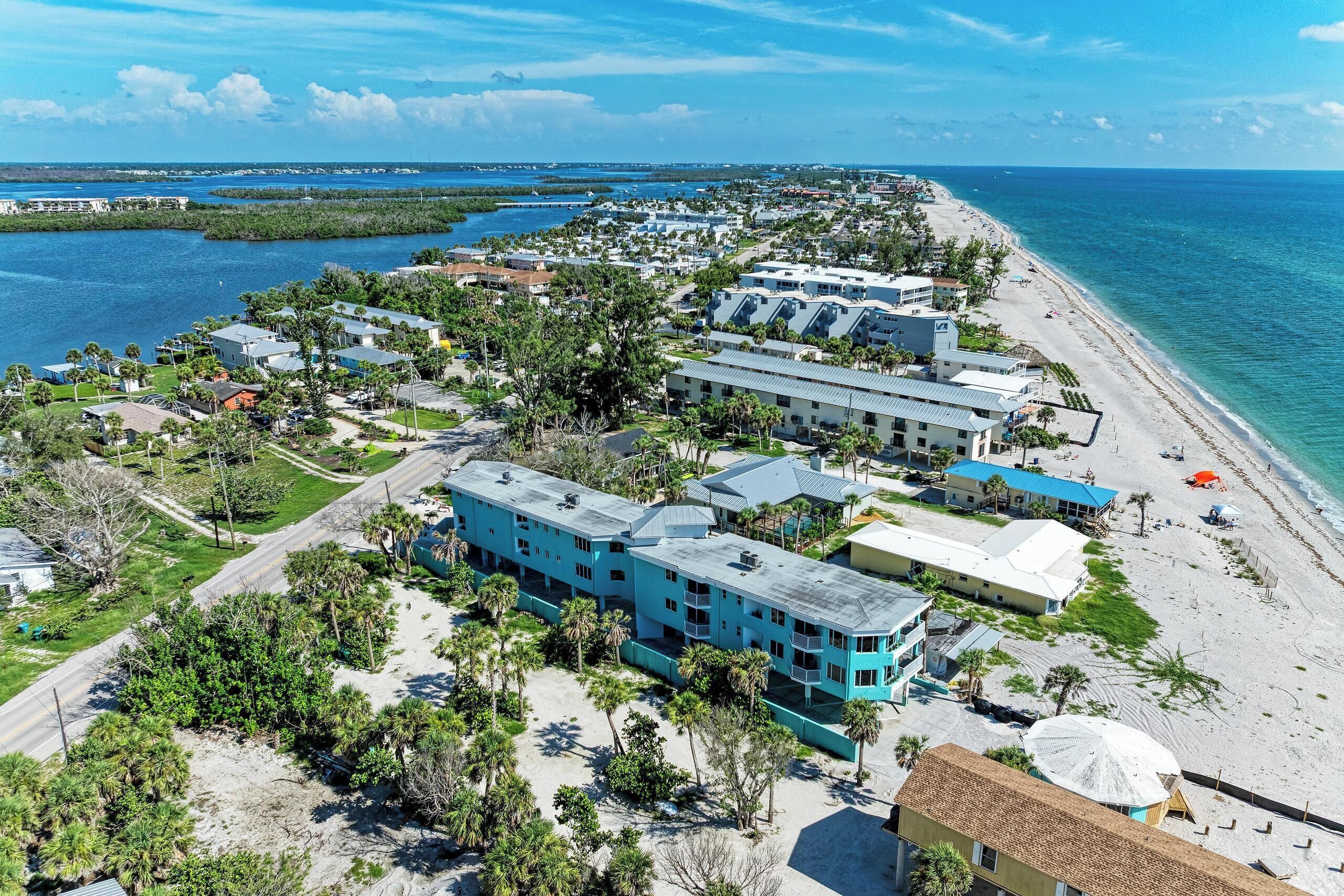 A coastal hotel with multiple buildings, a beach, and a marina.