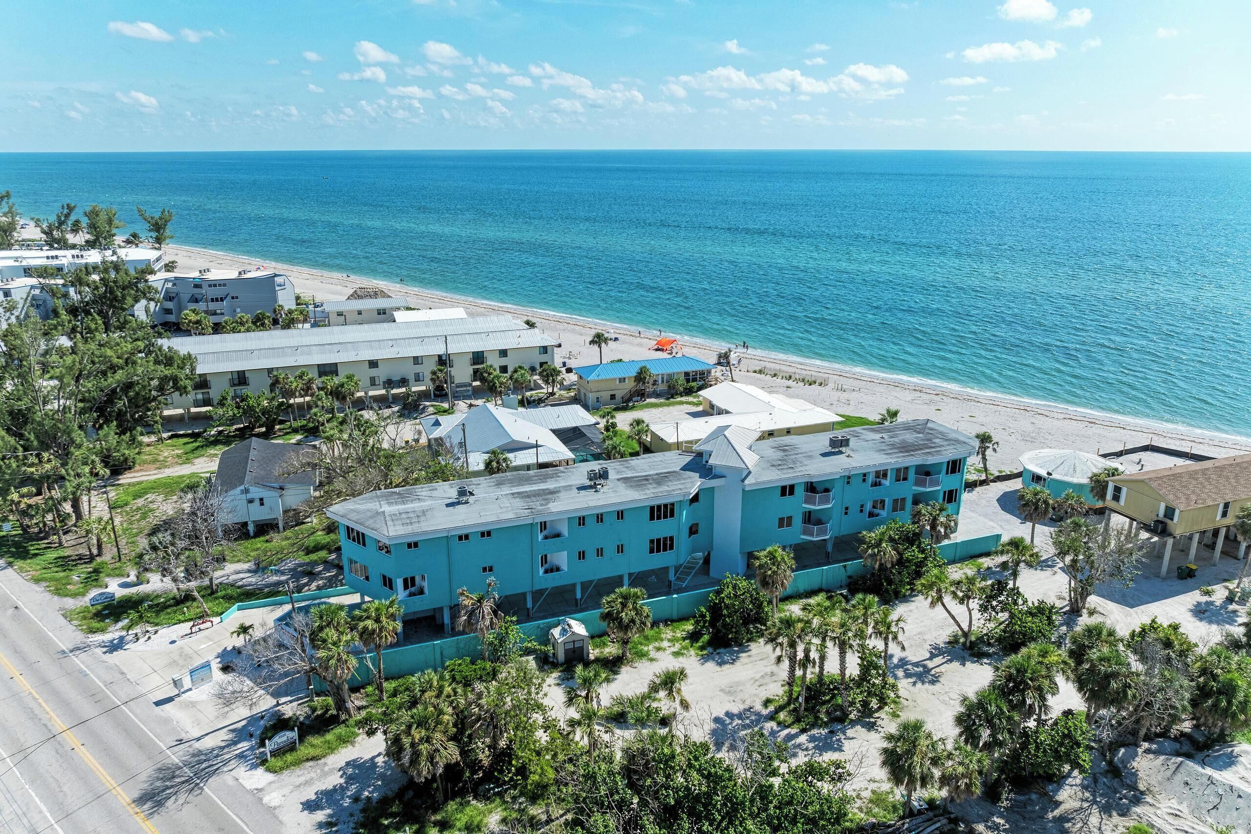 Un hotel costero con varias construcciones, una playa y una vista despejada del océano.