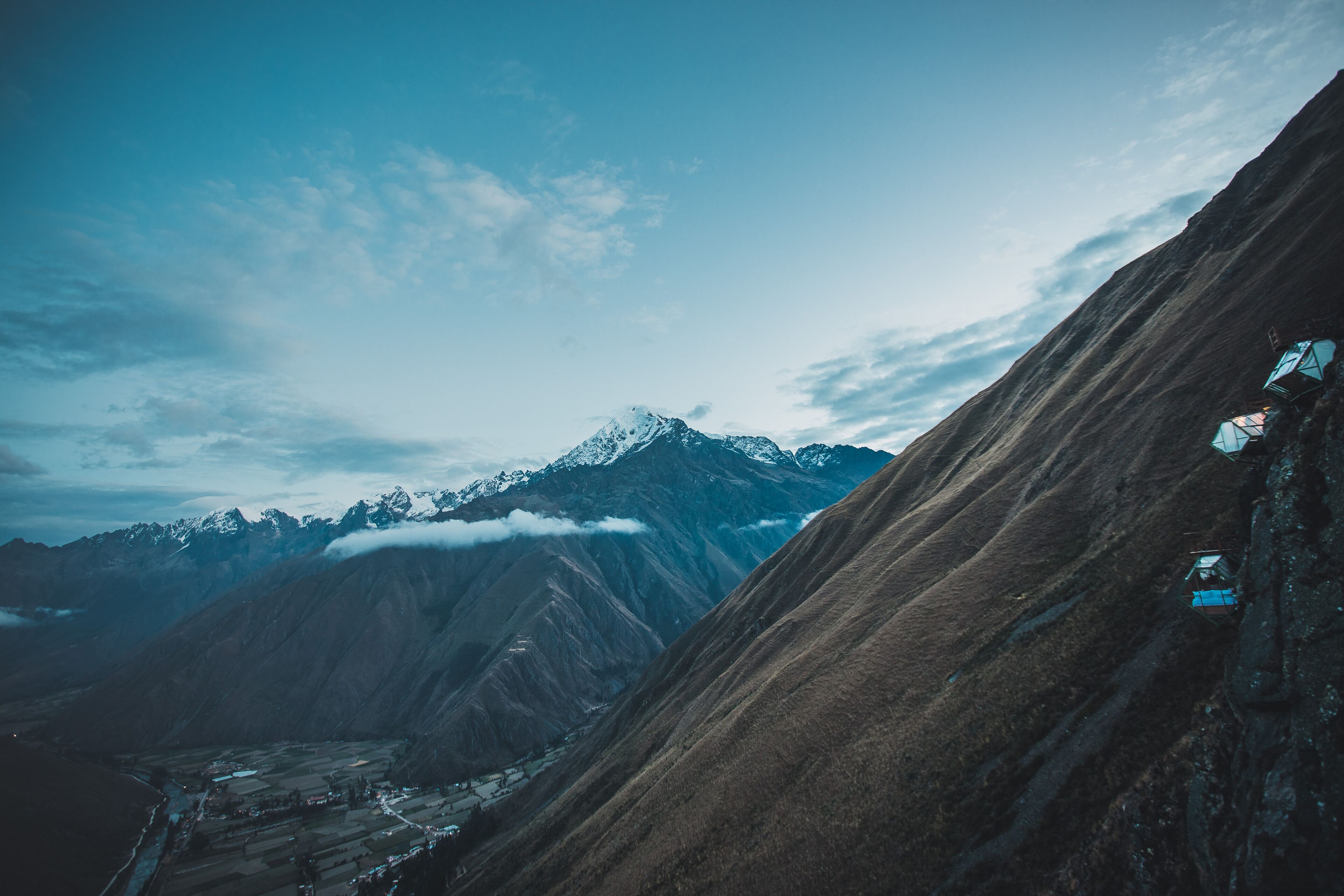 A mountainous landscape with a clear sky and a distant snow-capped peak.